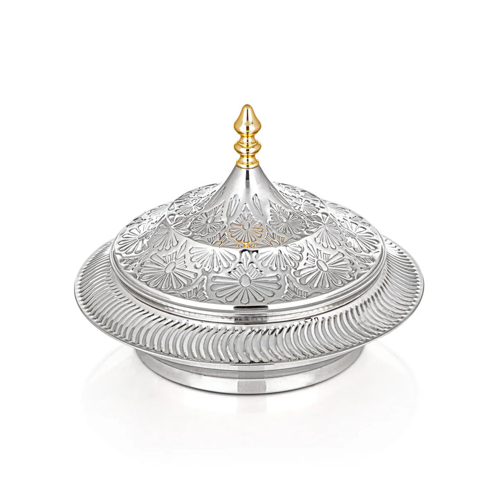 Decorative silver container with intricate designs on a white background