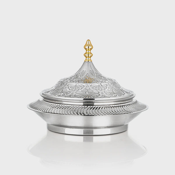 Decorative silver container with intricate designs on a white background