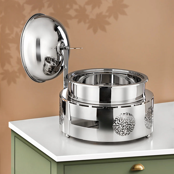 Silver metal container with intricate designs on a beige background