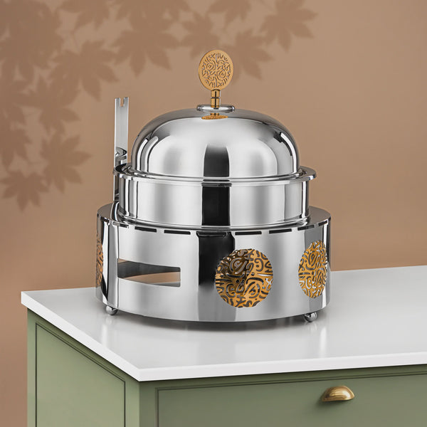 Stainless steel chafing dish with decorative elements on a beige background