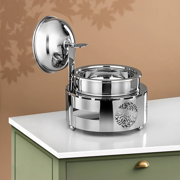 Silver decorative container with lid on a white surface against a beige wall