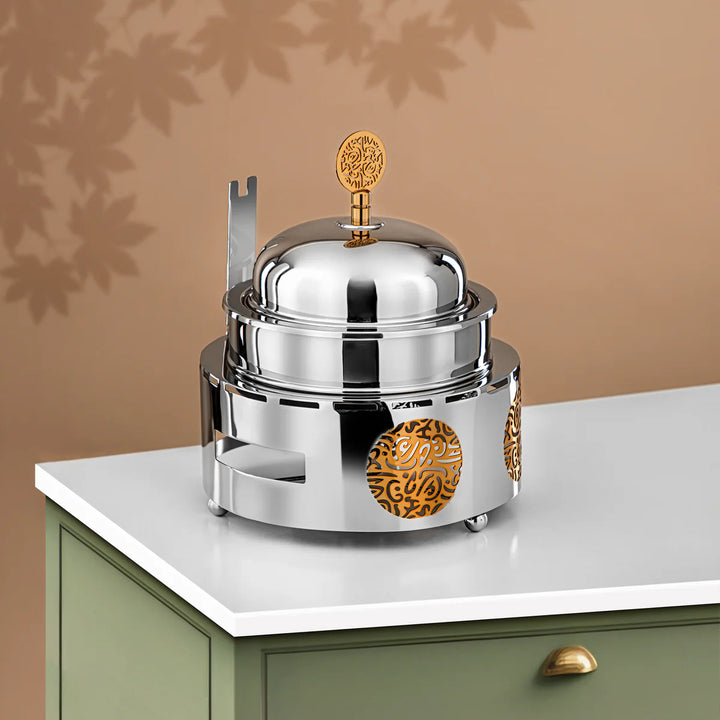 Silver and gold decorative item on a white surface with a brown background