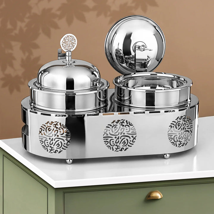 Silver decorative canisters with intricate designs on a white surface.