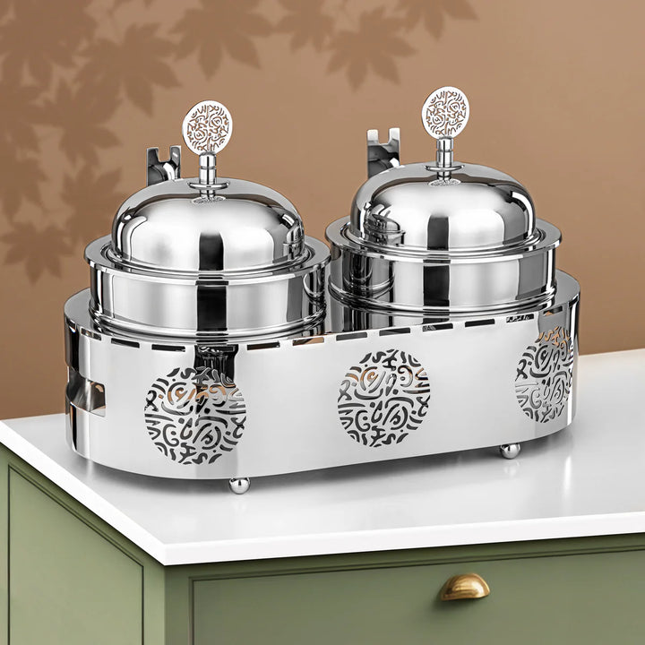 Two silver covered containers with decorative patterns on a white surface.