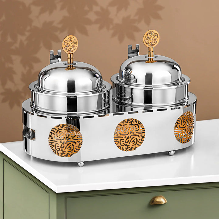 Two silver serving dishes with gold accents on a white surface.