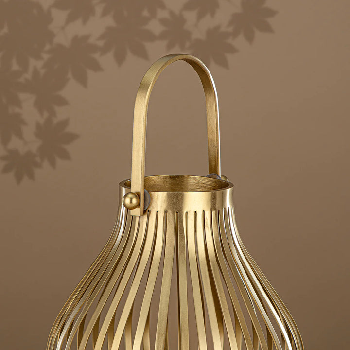 Gold metal lantern with handle on a brown background