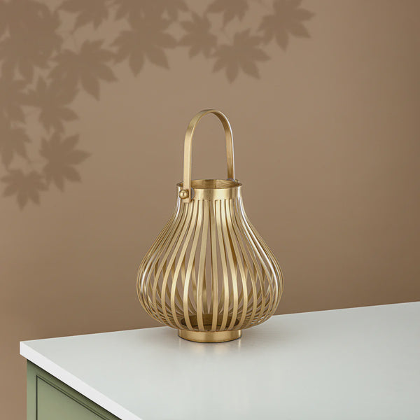 Gold lantern on a white surface with a brown wall background