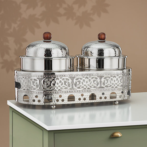 Decorative silver serving set with two covered dishes on a white surface.