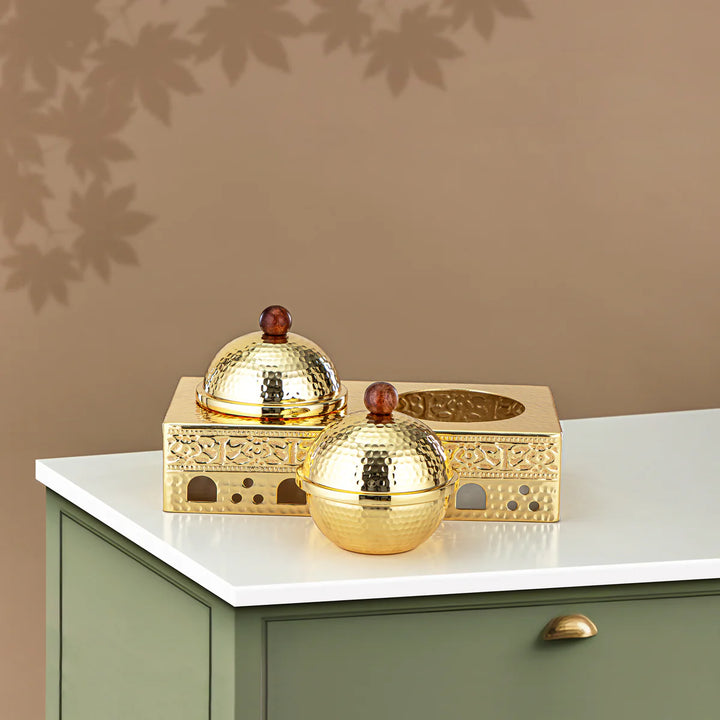 Decorative gold items on a white surface with a beige wall background