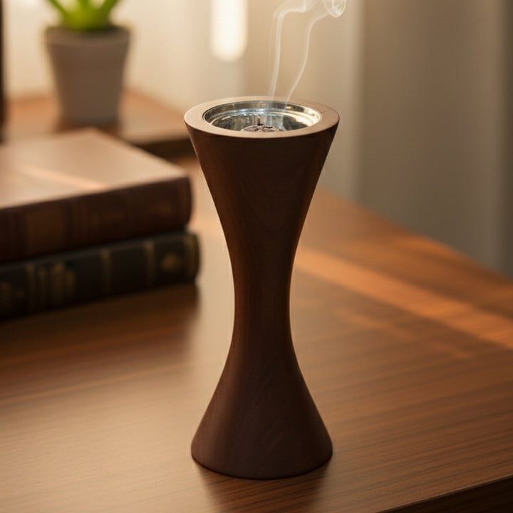 Wooden incense burner with smoke on a wooden surface