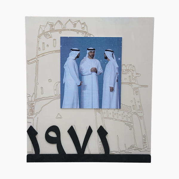 Decorative photo frame with Arabic calligraphy and a picture of three men in traditional attire.