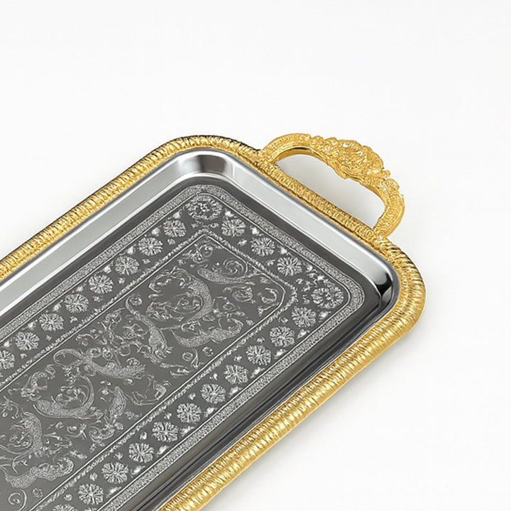 Decorative tray with gold handle and intricate silver design on a white background