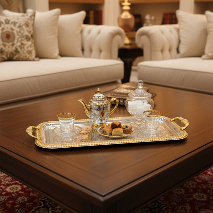 Decorative tea set on a tray with a blurred background of a living room.