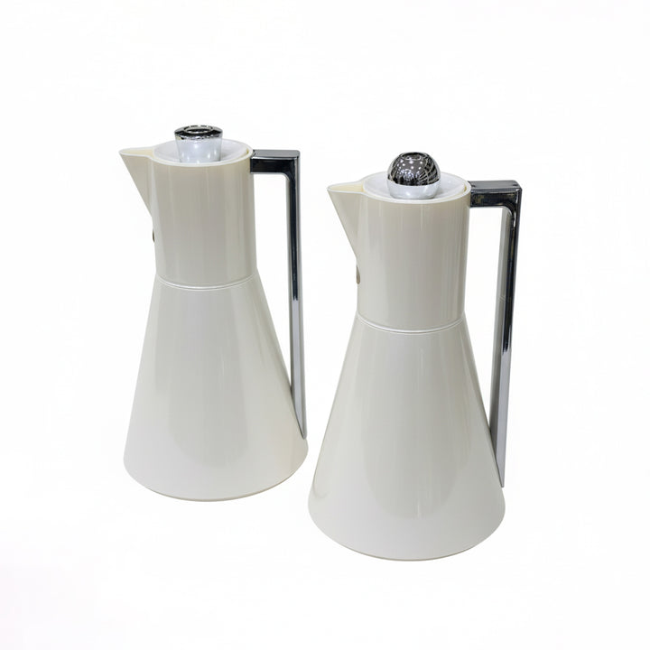 Two white ceramic pitchers with black nozzles on a white background