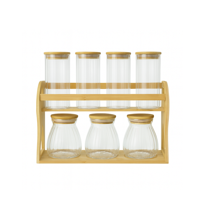 Set of glass jars with wooden lids on a wooden stand against a white background