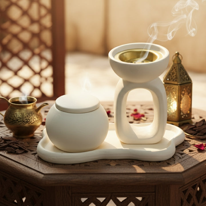 White ceramic tea set with a teapot and teacup on a wooden table with a warm background.