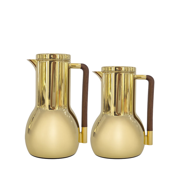 Two gold pitchers with wooden handles on a white background