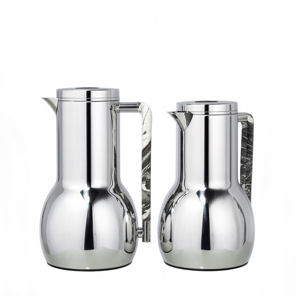 Two silver pitchers on a white background