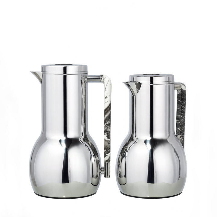 Two silver pitchers on a white background