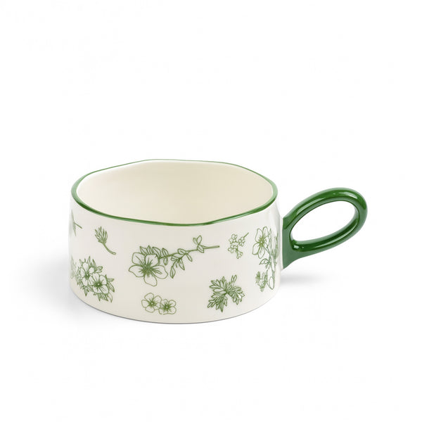 Ceramic mug with green floral patterns on a white background