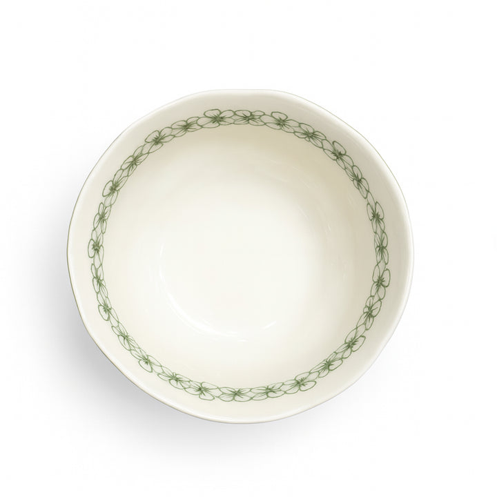 White ceramic bowl with green floral pattern on a white background