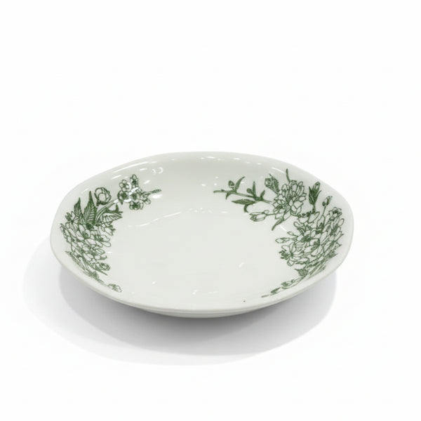White ceramic bowl with green floral patterns on a white background