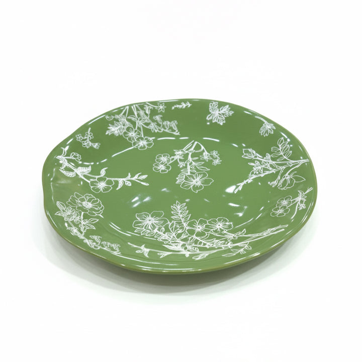 Green plate with white floral patterns on a white background