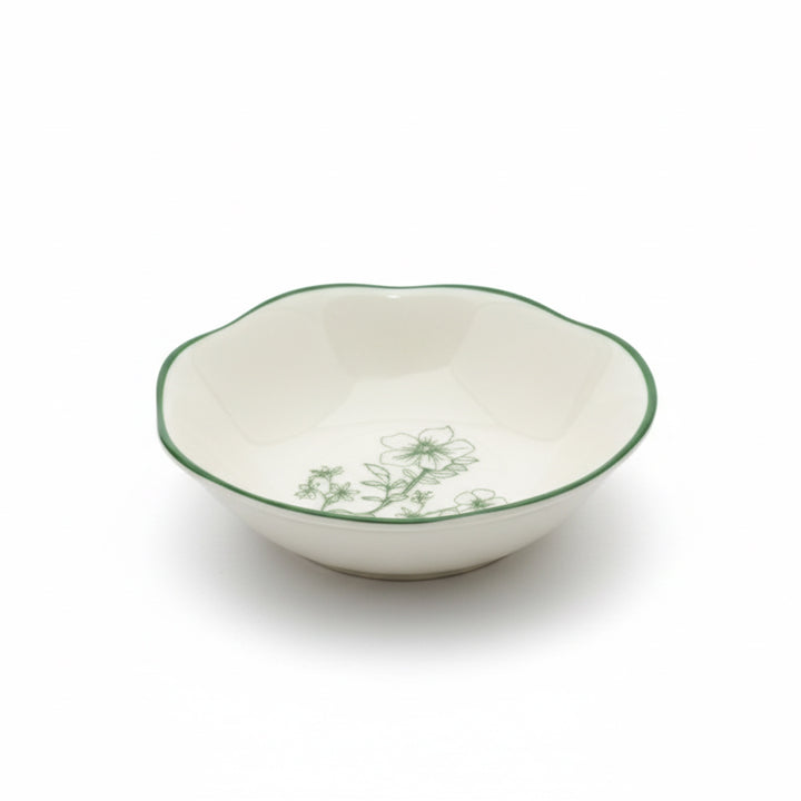 White ceramic bowl with green floral patterns on a white background