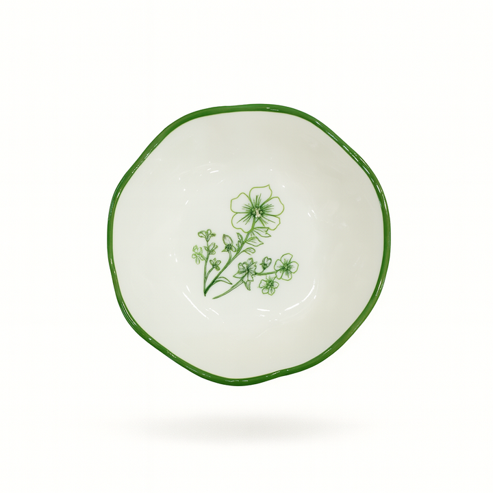 Small white bowl with green floral design on a white background