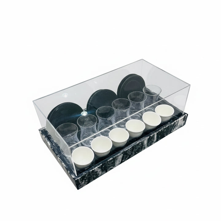 Set of black and white cups in a clear plastic container on a white background