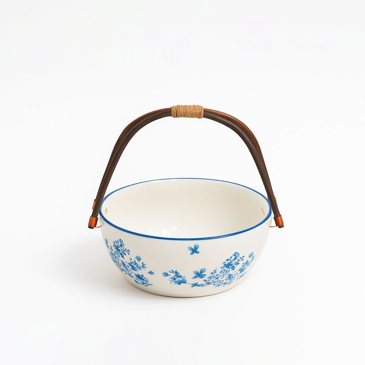 Ceramic bowl with blue floral pattern and brown handle on a white background