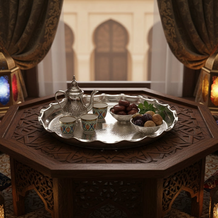 Tea set on a silver tray with dates on a wooden table in a decorated room.