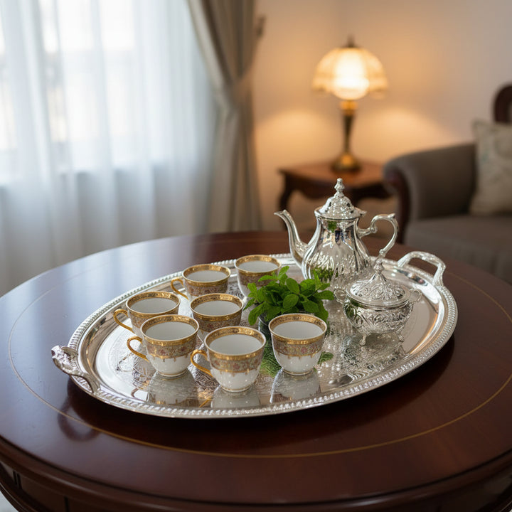 Silver tea set with teapot and cups on a tray in a living room setting