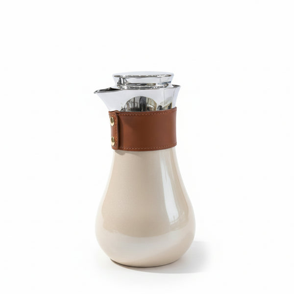White ceramic carafe with brown leather strap on a white background