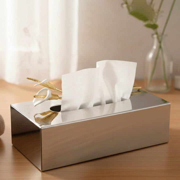 Silver tissue box with tissues on a wooden surface with a blurred background