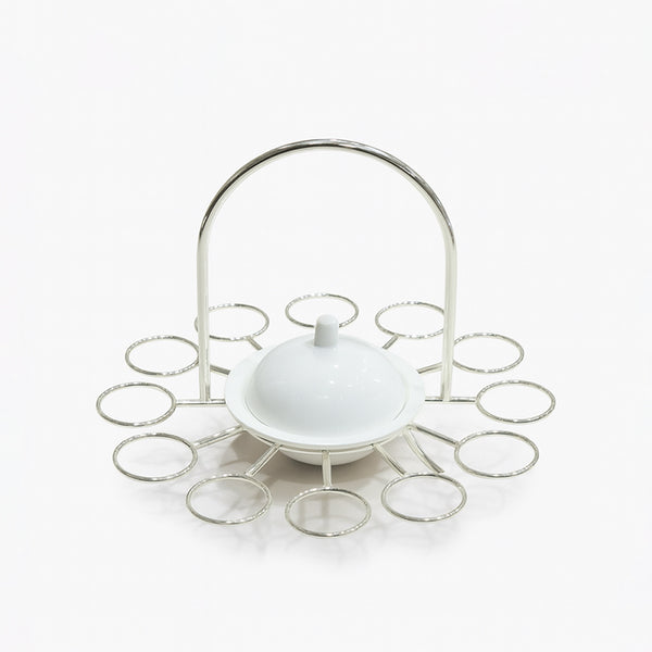 White ceramic dish with a lid on a decorative metal stand against a white background
