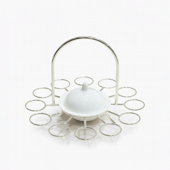 White ceramic dish with a lid on a decorative metal stand against a white background