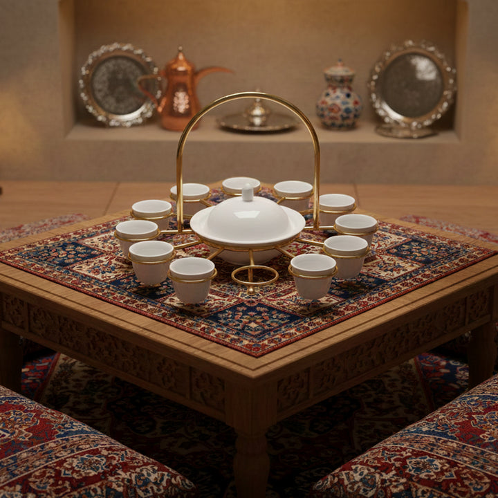 Tea set on a decorative table with a patterned rug and chairs in the background