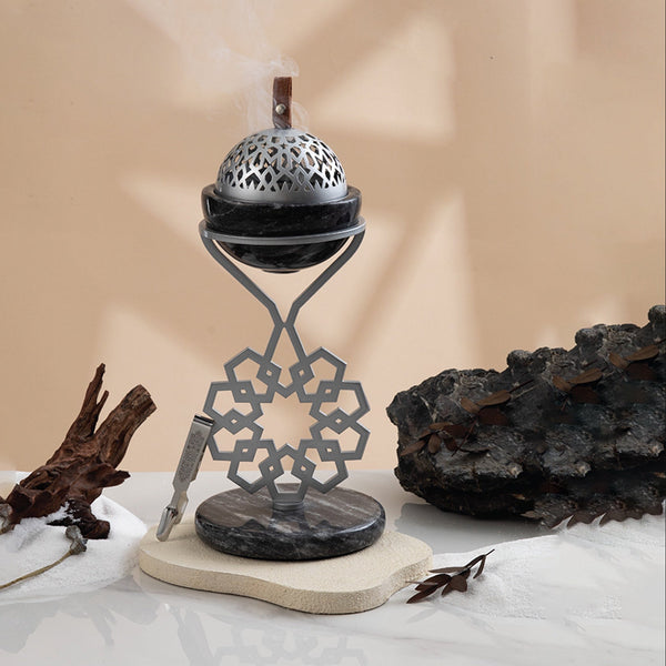 Decorative incense burner with intricate design on a neutral background