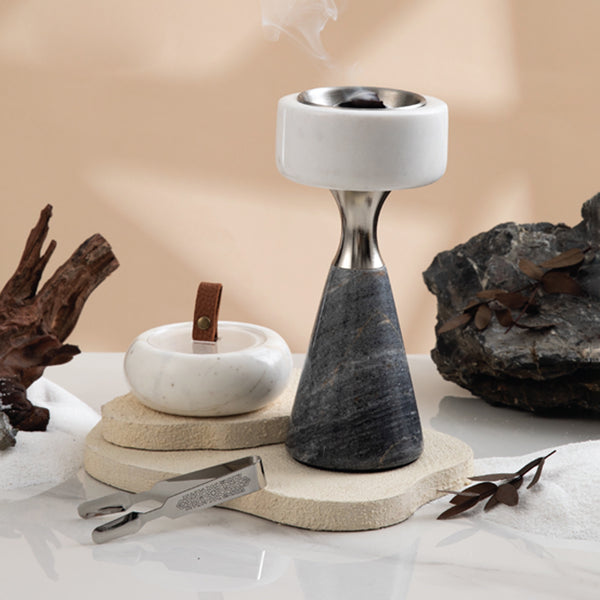 Decorative stone incense burner with natural elements on a neutral background