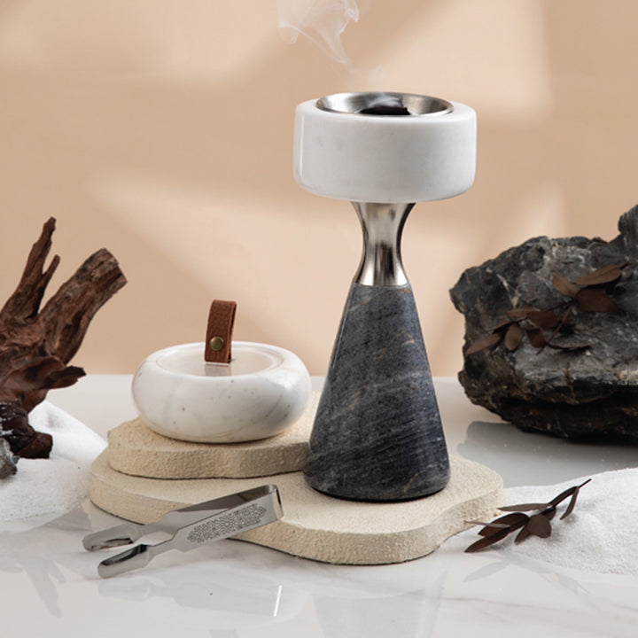 Decorative stone incense burner with natural elements on a neutral background