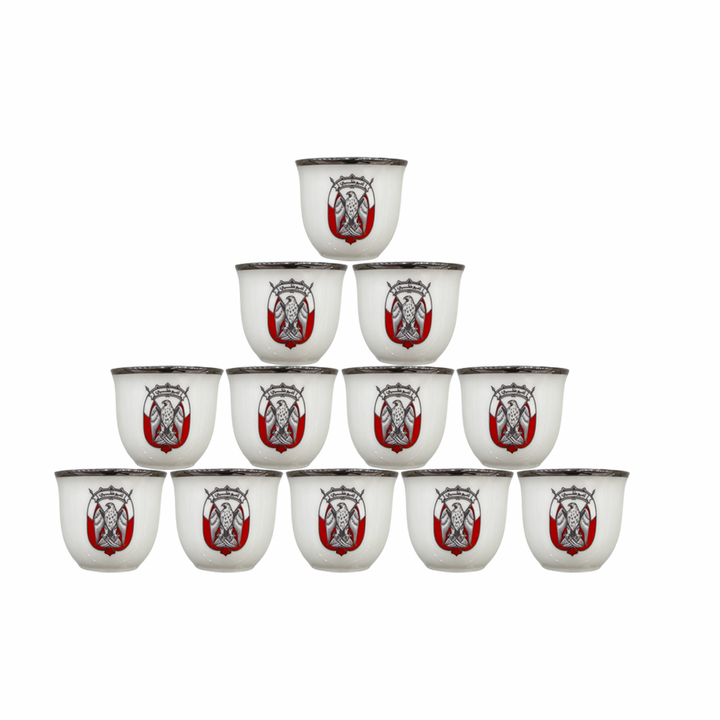 Set of twelve white cups with red and black designs on a white background