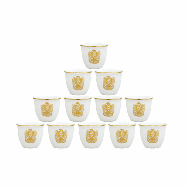 Set of twelve white cups with gold decorative elements on a white background